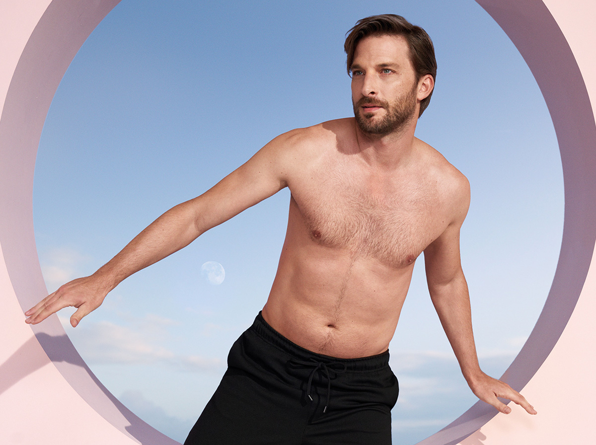 Sportlicher Mann vor blau-rosa Hintergrund
